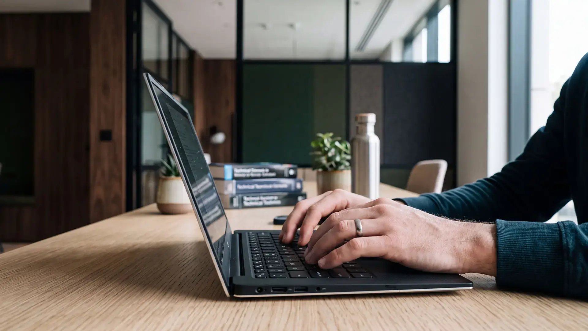 A telecom engineer's hands on the laptop keyboard as he works with Service Assurance and Customer Experience Management for 5G networks
