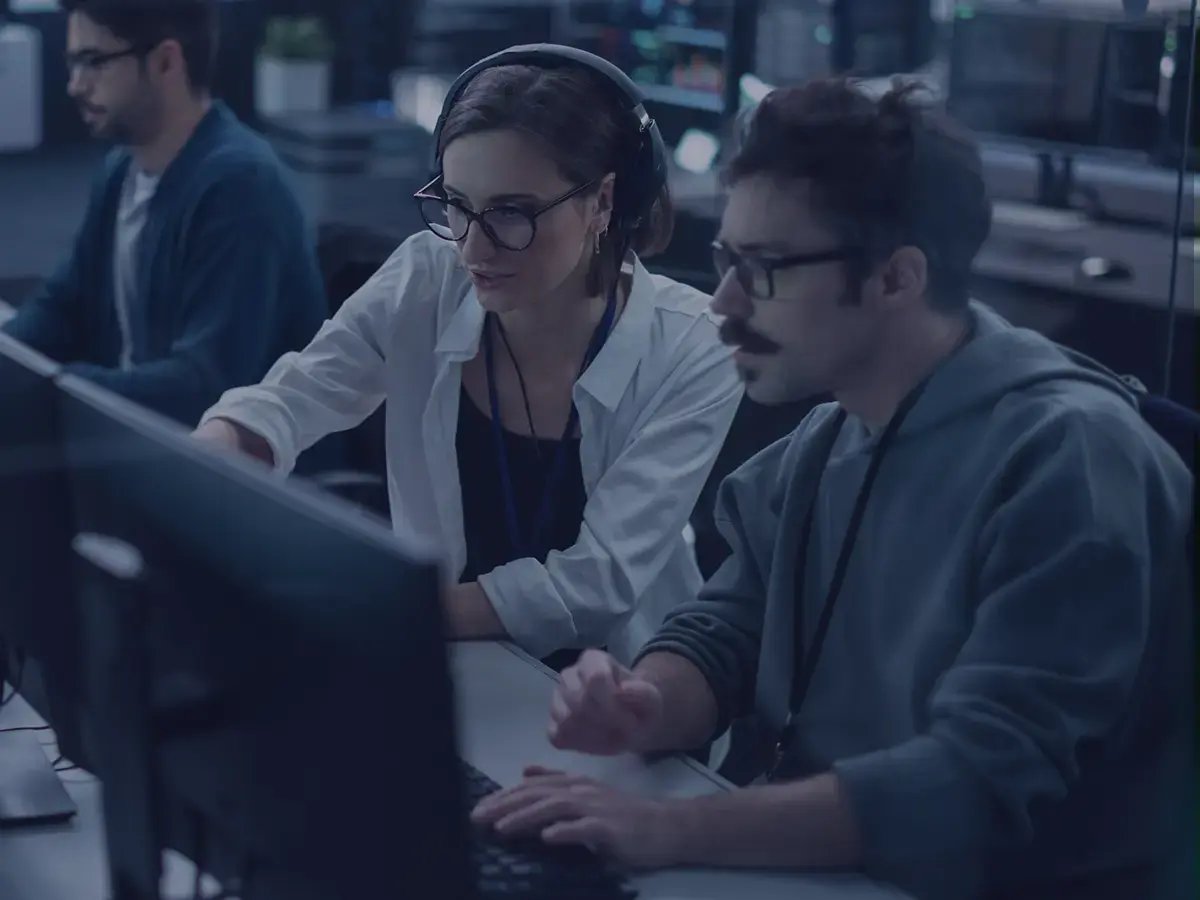 A man and a woman working in a telecom service operations center
