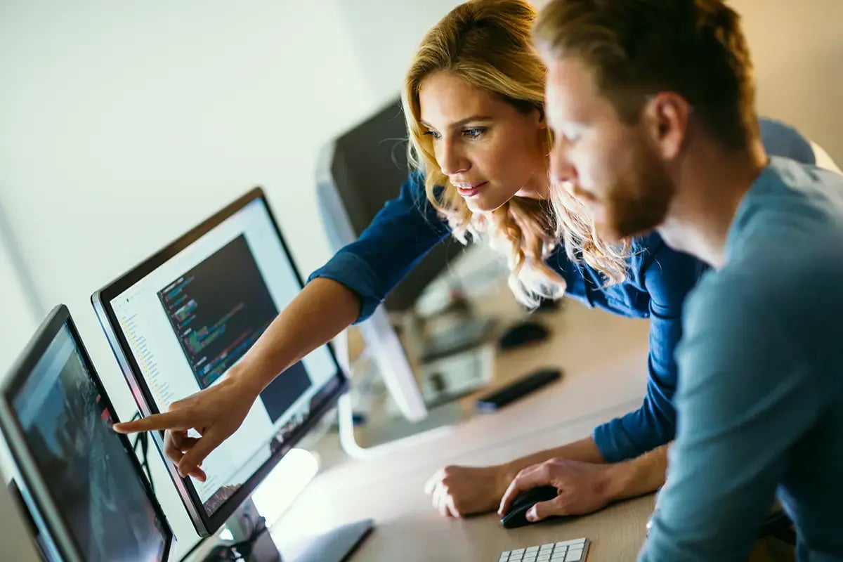 A man and a woman combining data sources to improve operational efficiency in telecom operations