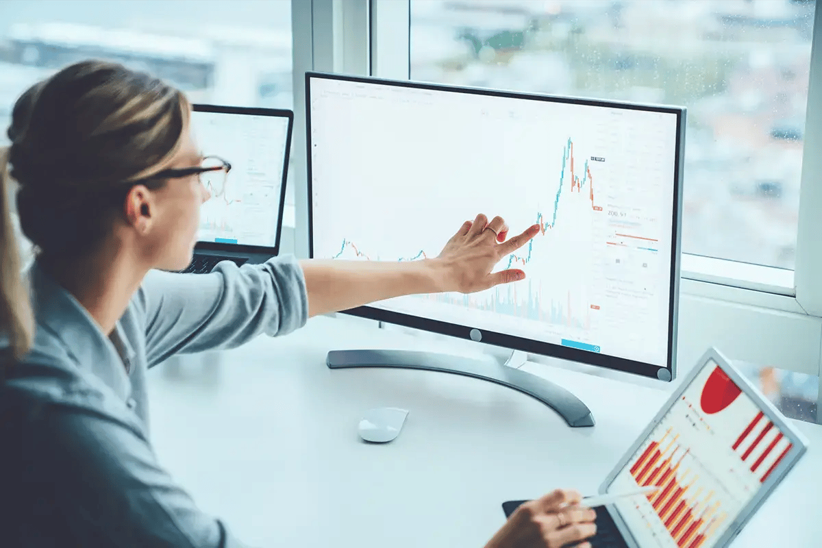 Woman working with telecom analytics on her desktop and laptop screens