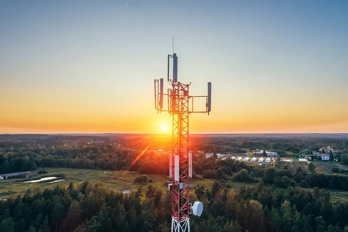 A telecom tower in the country-side with sunset in the background