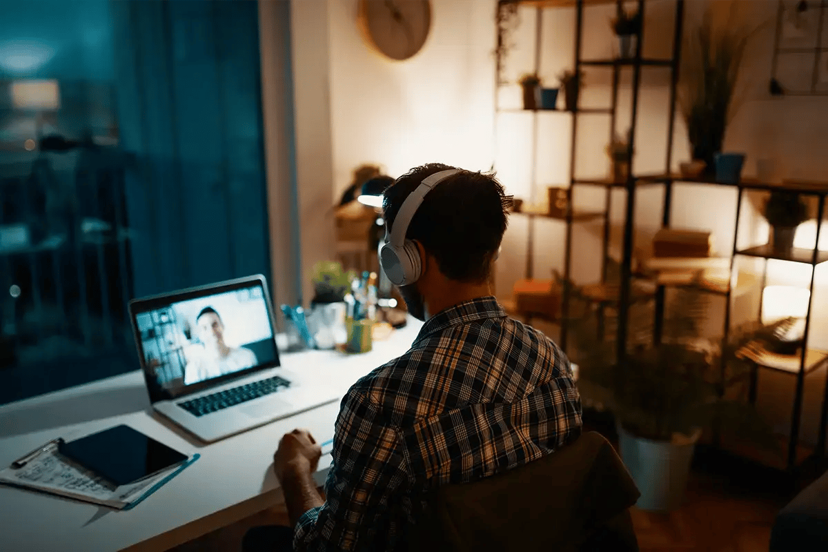 Young man having a web meeting on laptop at home