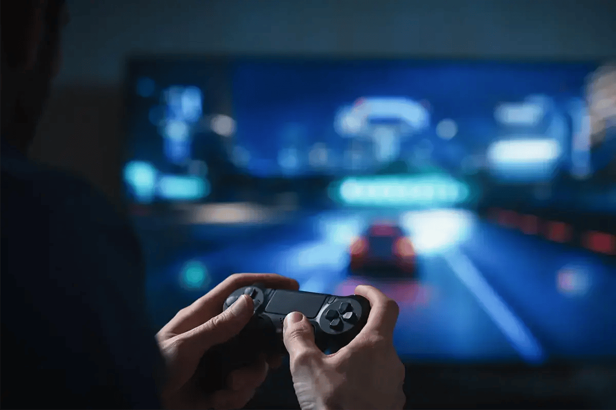 A man playing computer games at home using Fixed-Broadband internet connection