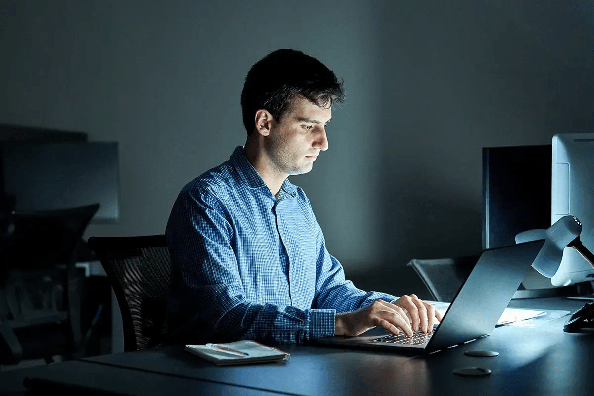 Man working on his laptop in a dark room