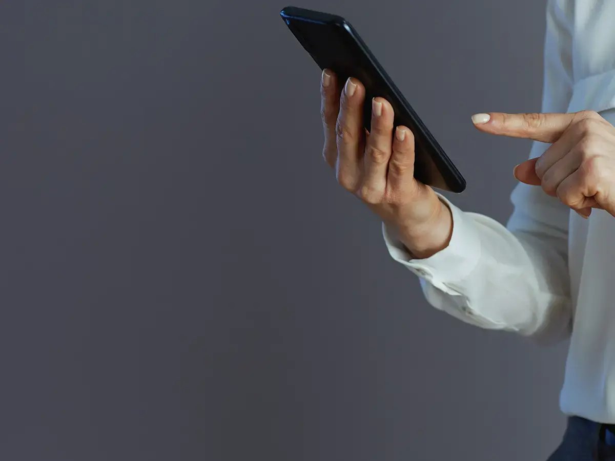 Woman hands on mobile phone with dark grey background