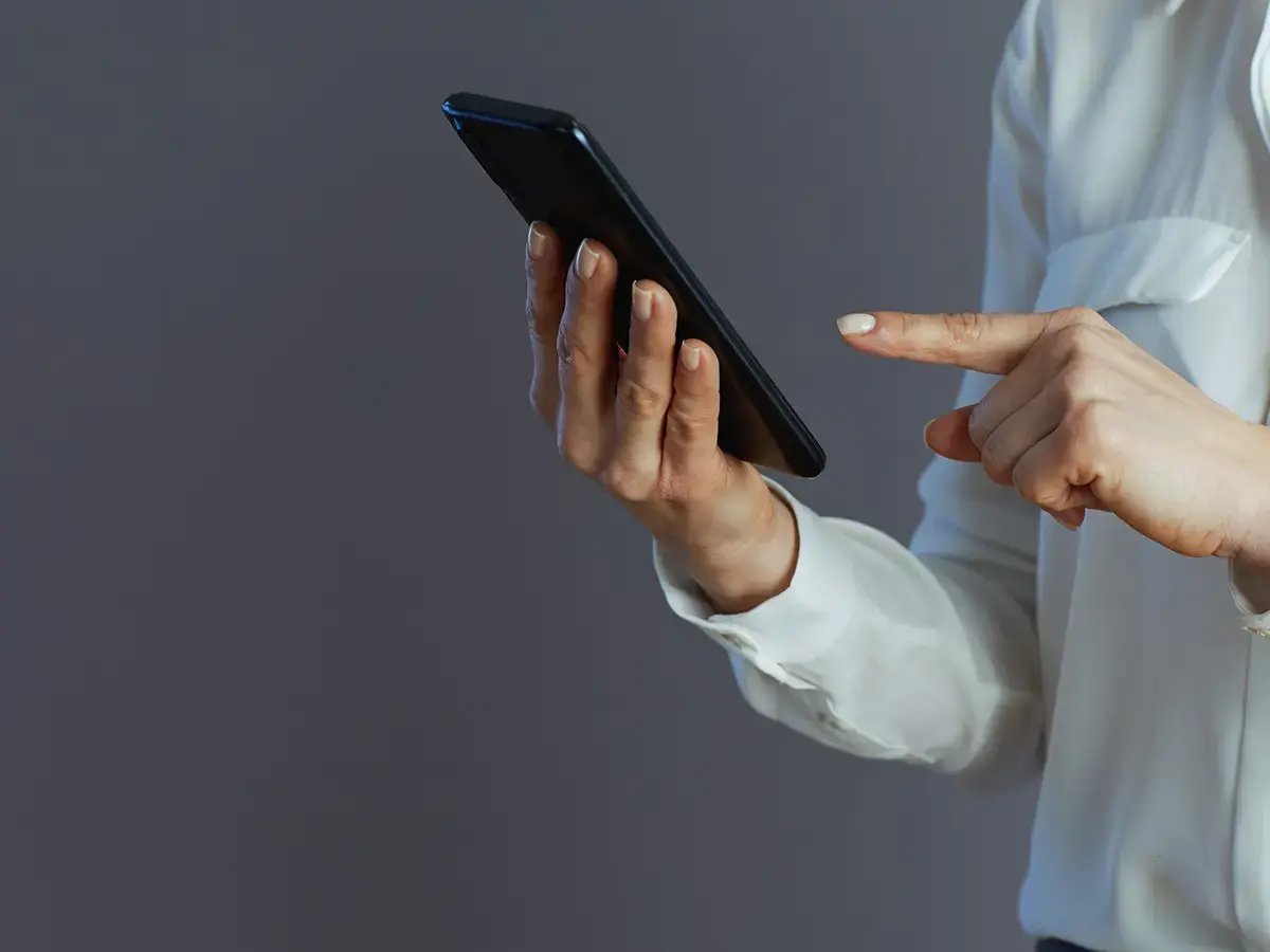 Woman hands on mobile phone with dark grey background