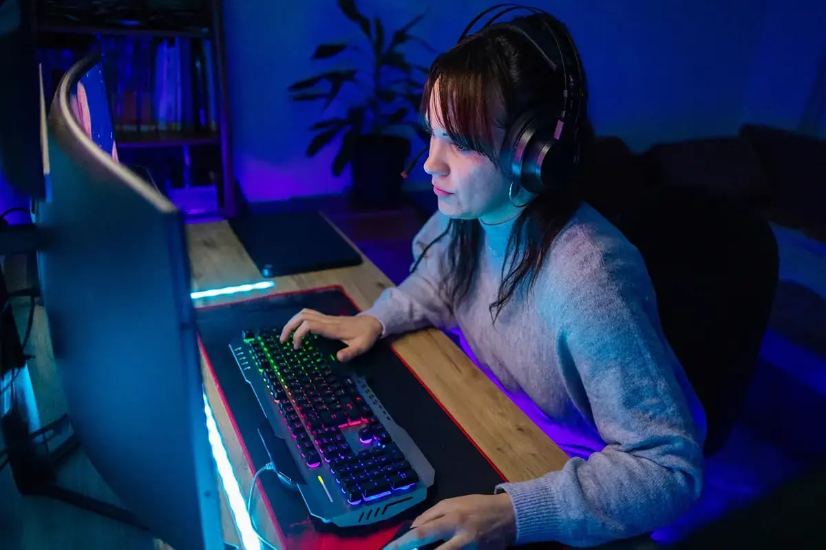 Young Woman who is gaming on her home desktop computer