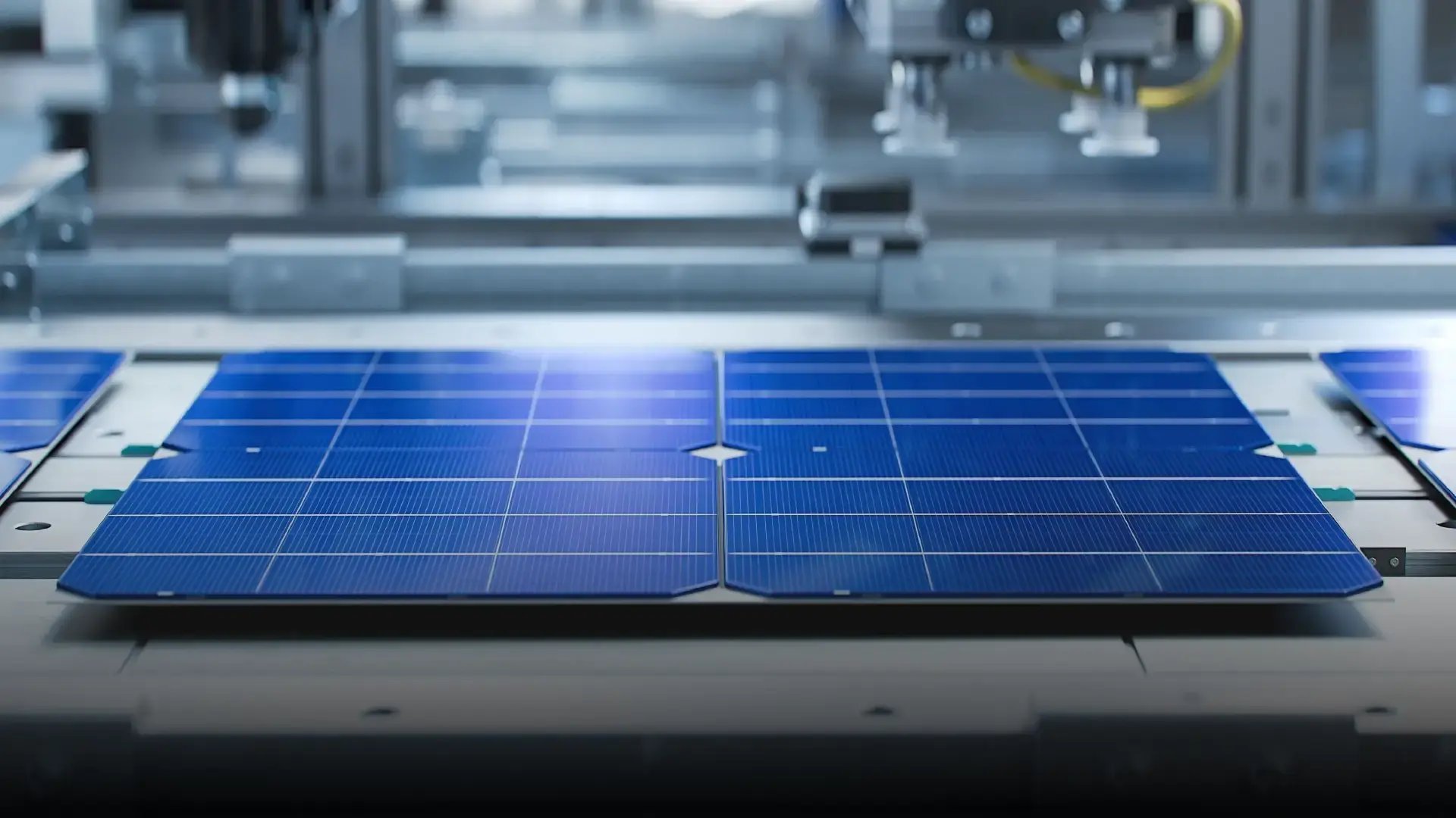 Close-up of blue photovoltaic solar panels in a manufacturing setting, emphasizing solar technology production.
