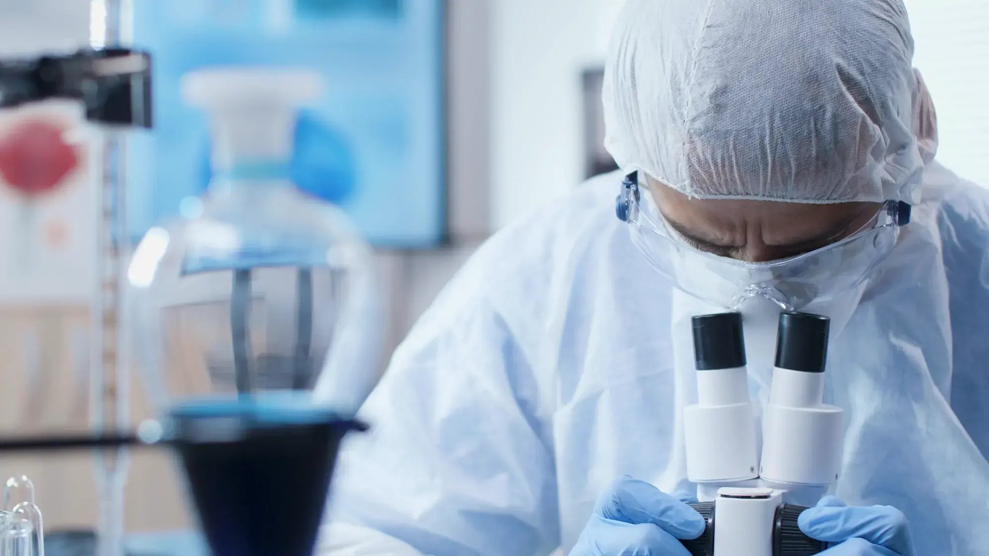 chemist-researcher-doctor-wearing-ppe-equipment-prevent-infection-with-coronavirus-analyzing-virus-sample-using-microscope-working-medical-vaccine-chemistry-laboratory-medicine-concept