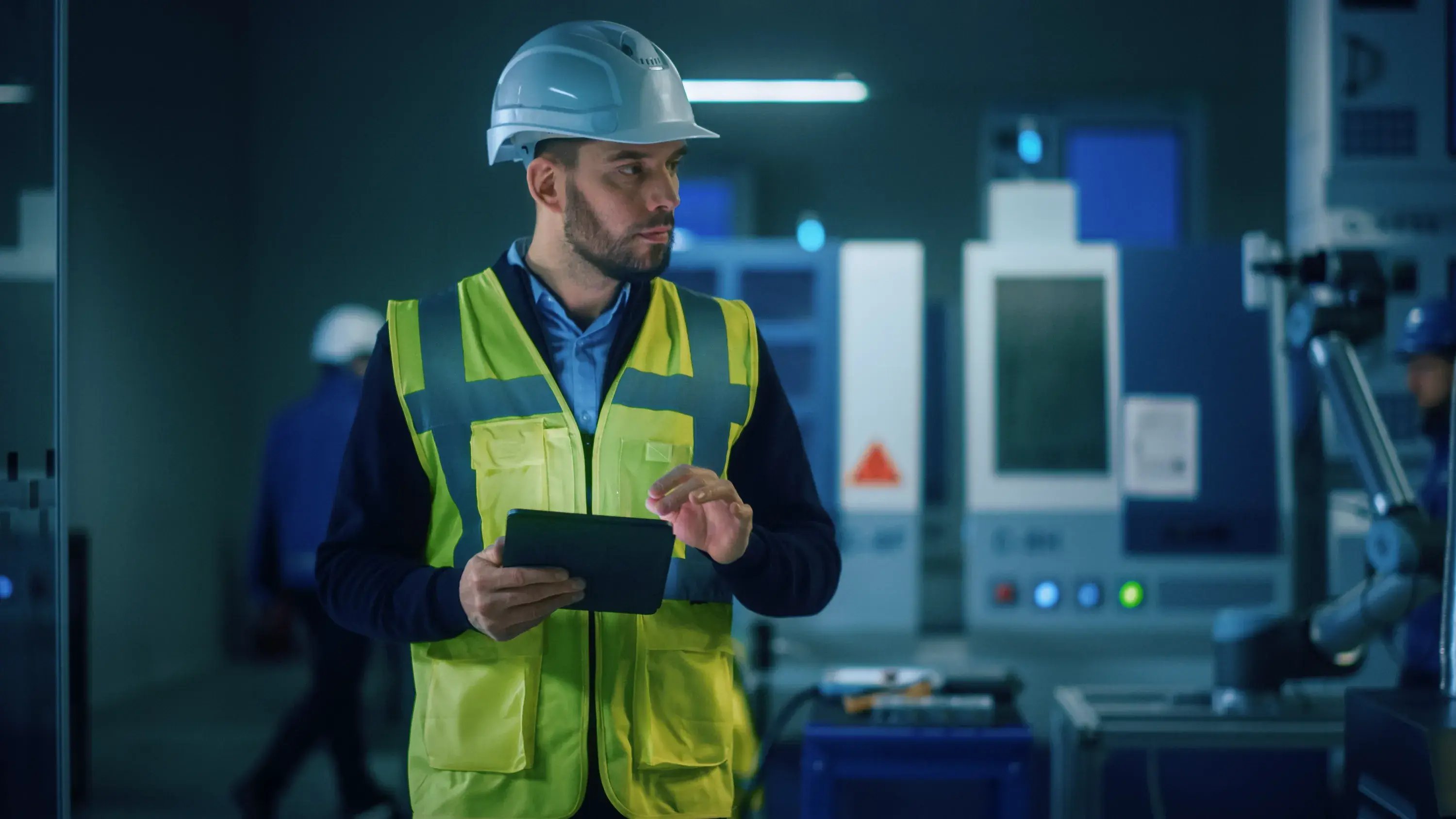 professional-engineer-wearing-safety-vest-hardhat-stands-modern-factory-workshop-uses-digital-tablet-computer-handsome-professional-working-industrial-facility-with-high-tech-machinery