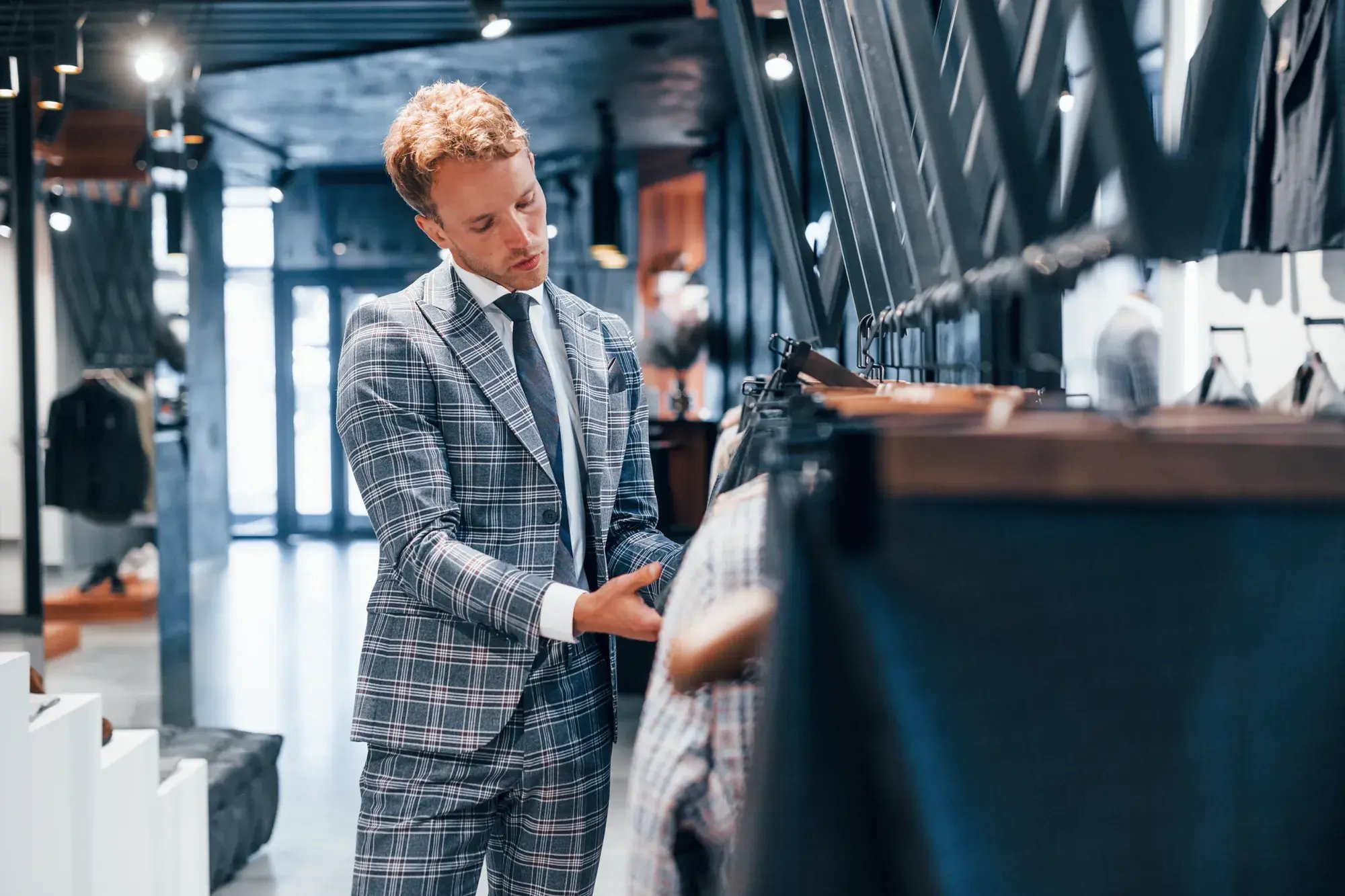 young-guy-modern-store-with-new-clothes-elegant-expensive-wear-men