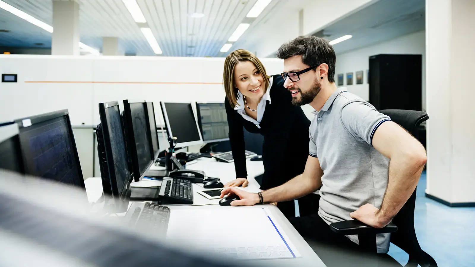 Two telecom professionals working together with automated network monitoring