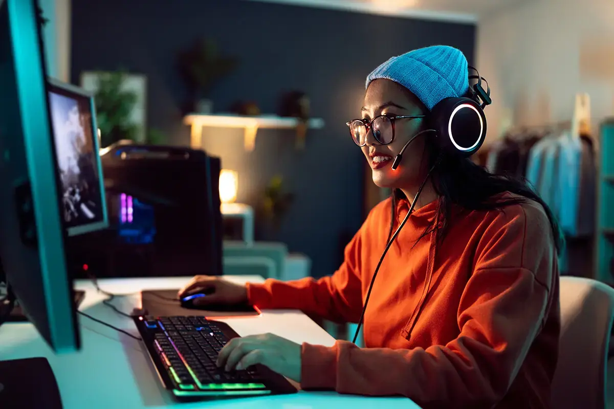 Young woman in beanie in front of here home gaming computer