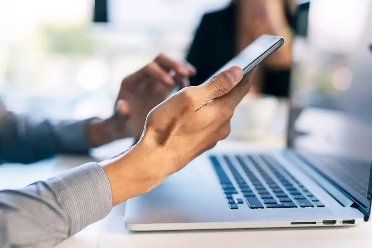 Mail hands working with a smartphone and a laptop